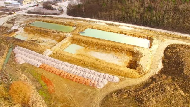 Camera flight over a sedimentation pools from sewage treatment for industrial use. Industry and environment from above.