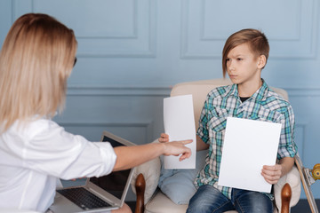 Angry teenager holding two paper sheets