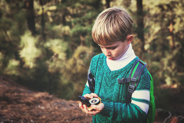 little boy travels with compass in forest © nadezhda1906