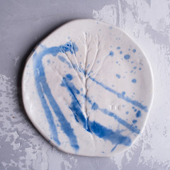 Different antique vintage multicolored empty plates and bowls on a white old wooden table. Table setting. Shabby chic retro style. Rustic kitchen. Set of plates. Toned image