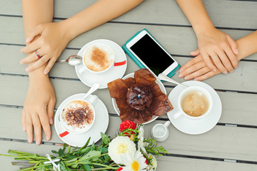 Chocolate muffin with one candle, cups with coffee on wooden table .