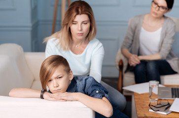 Angry teenager lying on the back of sofa