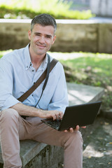 Fototapeta premium Man using a laptop outdoors