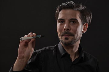 Portrait of man who is smoking electronic cigarette.