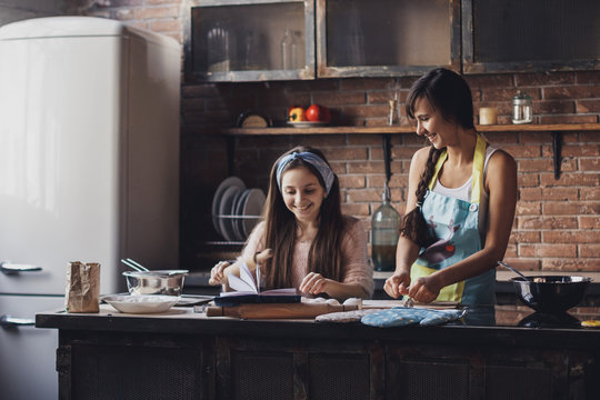 Young Woman With Her Little Sister Cooking Holiday Pie