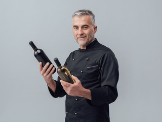 Chef choosing a wine bottle - obrazy, fototapety, plakaty