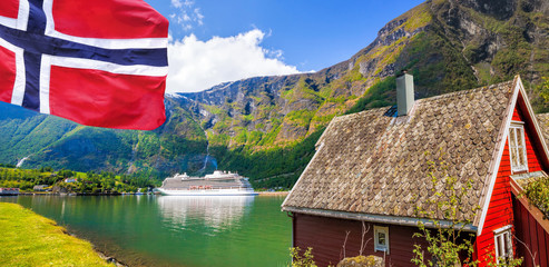 Red cottage against cruise ship in fjord, Flam, Norway