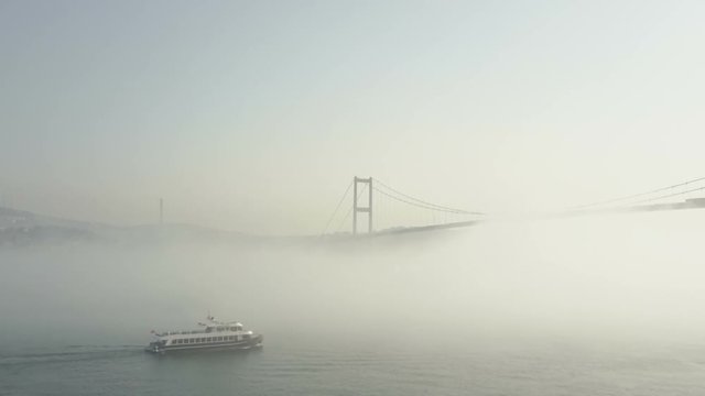 Bosphorus view on a foggy day in Istanbul, Turkey. The fog creates an unusual mystical ambiance with the Bosphorus Bridge at the background a boat in the foreground.