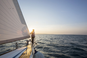 Man Standing On Front Of Luxury Yacht In Sea - Powered by Adobe