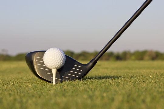 Closeup image of a golf blue preparing to hit a golf ball.