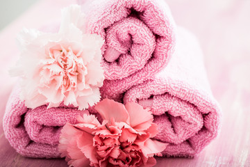 Obraz na płótnie Canvas Rolled pink towel with flowers