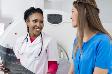 Female Doctor Holding Chest X-ray While Looking At Patient