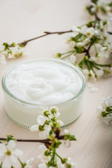 Fototapeta na wymiar Face cream with spring flowers on white background