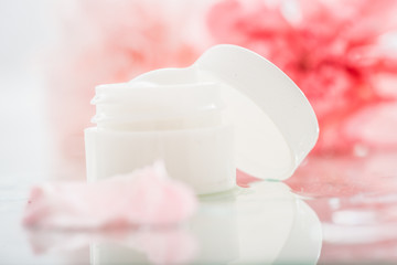 Face cream with spring flowers on white background