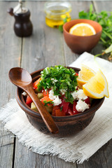 Fresh Salad Shopska of baked peppers, tomato, onion, cucumber, parsley, dill and feta cheese in a ceramic bowl. Traditional Serbian food. Selective focus.
