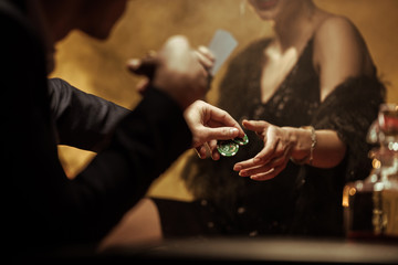 Partial view of elegant couple playing poker and sharing casino chips