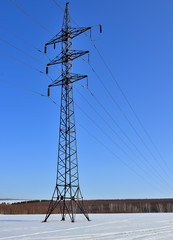 High voltage electricity pylon and winter blue sky