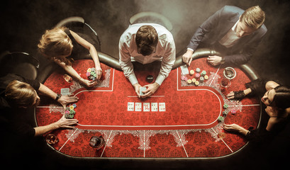 top view of men and women playing poker in casino - obrazy, fototapety, plakaty