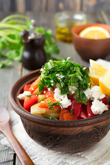 Fresh Salad Shopska of baked peppers, tomato, onion, cucumber, parsley, dill and feta cheese in a ceramic bowl. Traditional Serbian food. Selective focus.