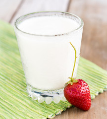 Summer healthy food. A glass of dairy product ( milk or yogurt ) and fresh ripe strawberry. 
