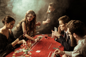 side view of people playing poker together in casino