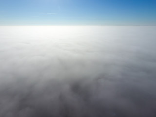 In the skies above the fog. Sunrise over the fog. Clouds near the ground
