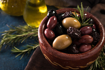 bowls with different kind of olives green olives, black olives, kalamata olives on table