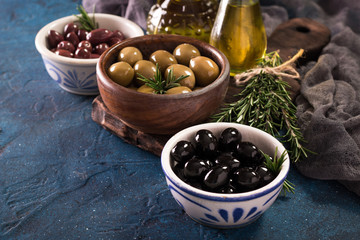 bowls with different kind of olives green olives, black olives, kalamata olives on table