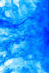 Abstract background. Blue ink in water, in motion. Color drop swirling. Colorful cloud of paint on white.