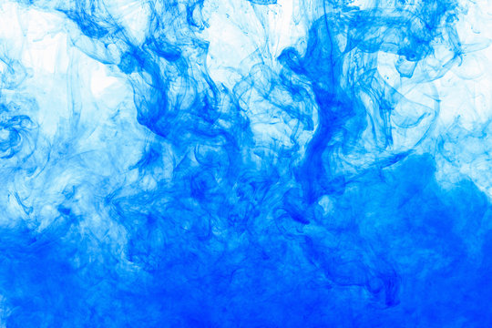 Abstract Background. Blue Ink In Water, In Motion. Color Drop Swirling. Colorful Cloud Of Paint On White.