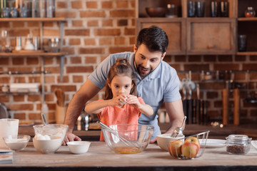 'portrait of father and daughter making cookies in kitchen