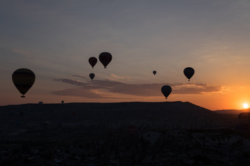 Hot air balloons silhouette over spectacular Cappadocia.