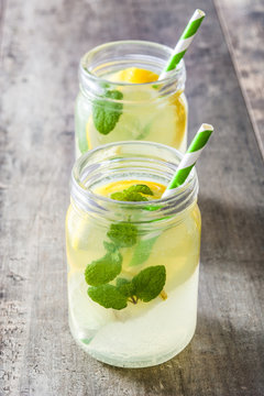 Lemonade drink in a jar glass on wooden background. Copyspace.
