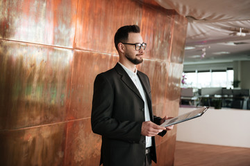 Side view of business man in suit with clipboard