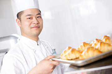 young man chelf makes bread in kitchen