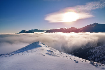 Sunrise at clouds covered Tatra mountain peaks