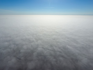 In the skies above the fog. Sunrise over the fog. Clouds near the ground