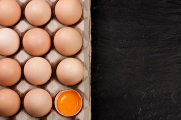 eggs in a tray on a dark background with copy space for your text. Top view