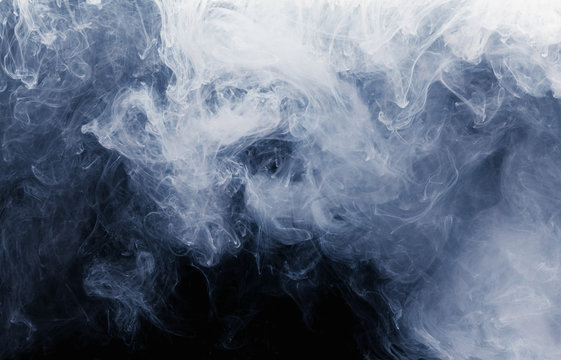 Abstract cloud pattern of white smoke on a black background. © bravissimos