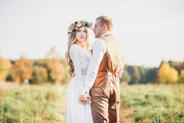 Beautiful bride and groom together in the field. - Powered by Adobe