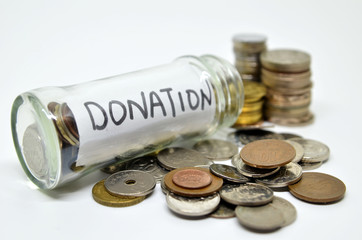 Donation lable in a glass jar with coins spilling out