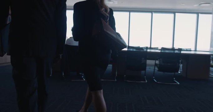 Businessman And Businesswoman Entering A Conference Room For Business Meeting. Business People Meet Up With Other Colleagues And Shake Hands.