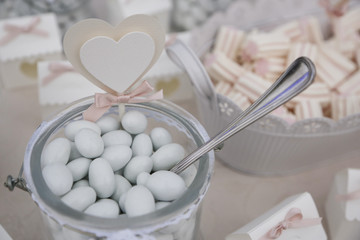 Fototapeta na wymiar Confetti su bicchiere in vetro con cucchiaino con sfondo altri dolciumi