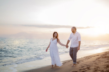 Fototapeta na wymiar Pregnant couple in love on the beach