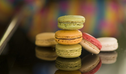 Sweet and colorful french macaroon (macaron) with reflection on solid black background