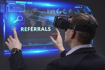 Business, Technology, Internet and network concept. Young businessman working on a virtual screen of the future and sees the inscription: Referrals