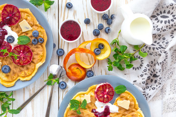 Belgium waffles with blueberry, blood orange, whipped cream. Breakfast