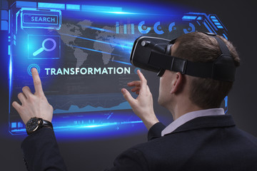 Business, Technology, Internet and network concept. Young businessman working on a virtual screen of the future and sees the inscription: Transformation