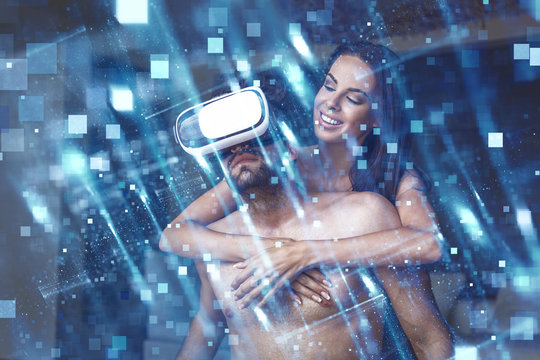 Young naked couple using VR headset virtual reality, indoor, glowing particles