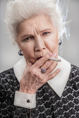 grandmother in elegant fashionable clothes smoking